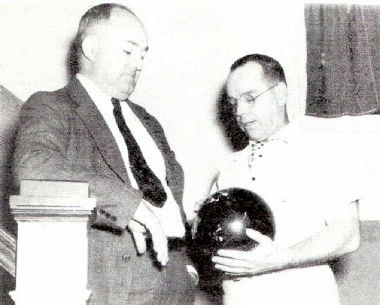 Just looking the situation over - League Secretary Edward Downey examines the ball Howard McCray, President of General Steel's A. A., rolled down the alley in the opening spin. Whether McCray knocked' em all flat in the first trial is quite a different matter.; Photo from The Delaware County Advocate, October 1940